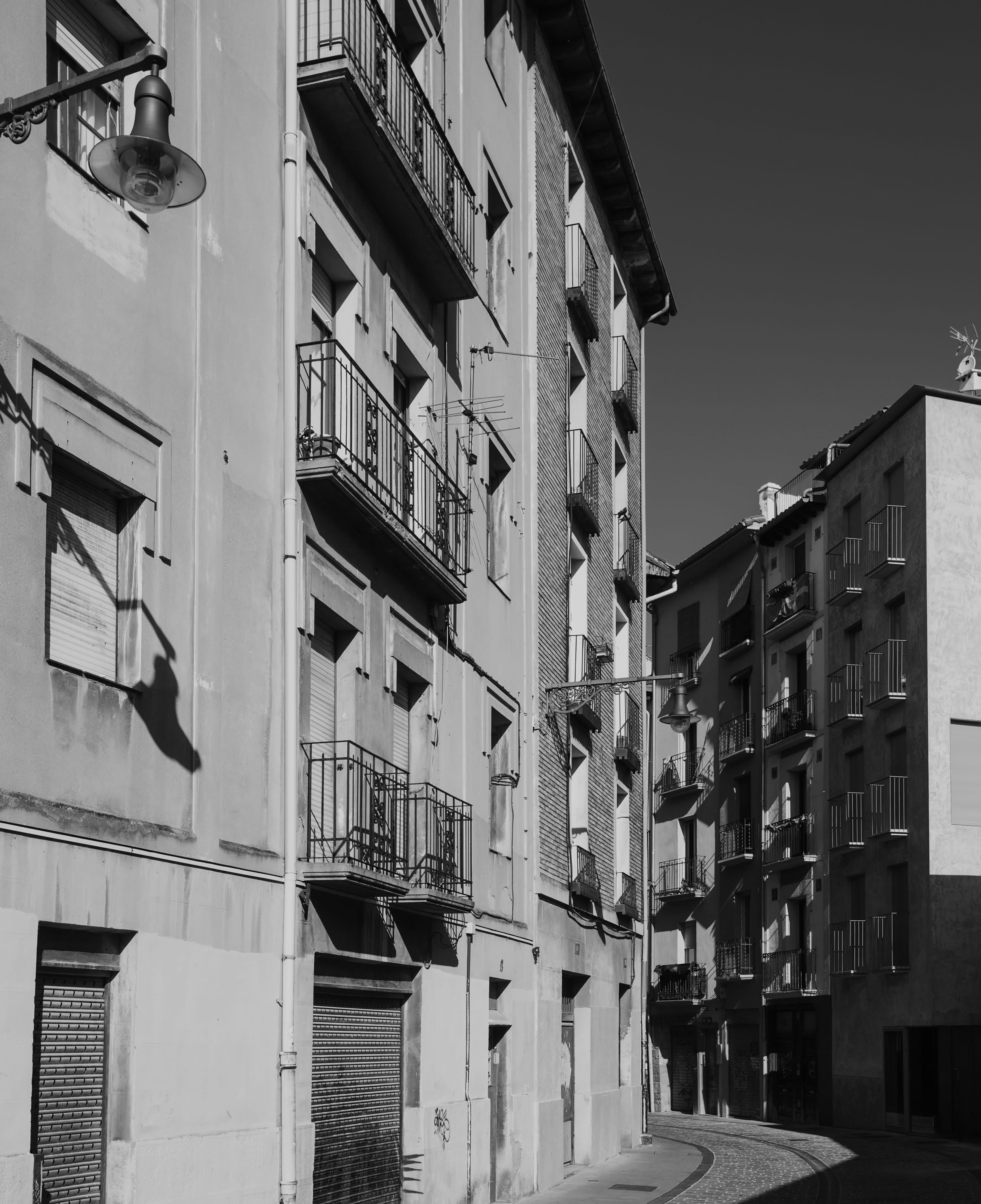Imagen generada con Imagen en blanco y negro que muestra la fachada de un edificio antiguoIA que muestra el terrado de un edificio que tiene placas solares y está construido con materiales sostenibles
