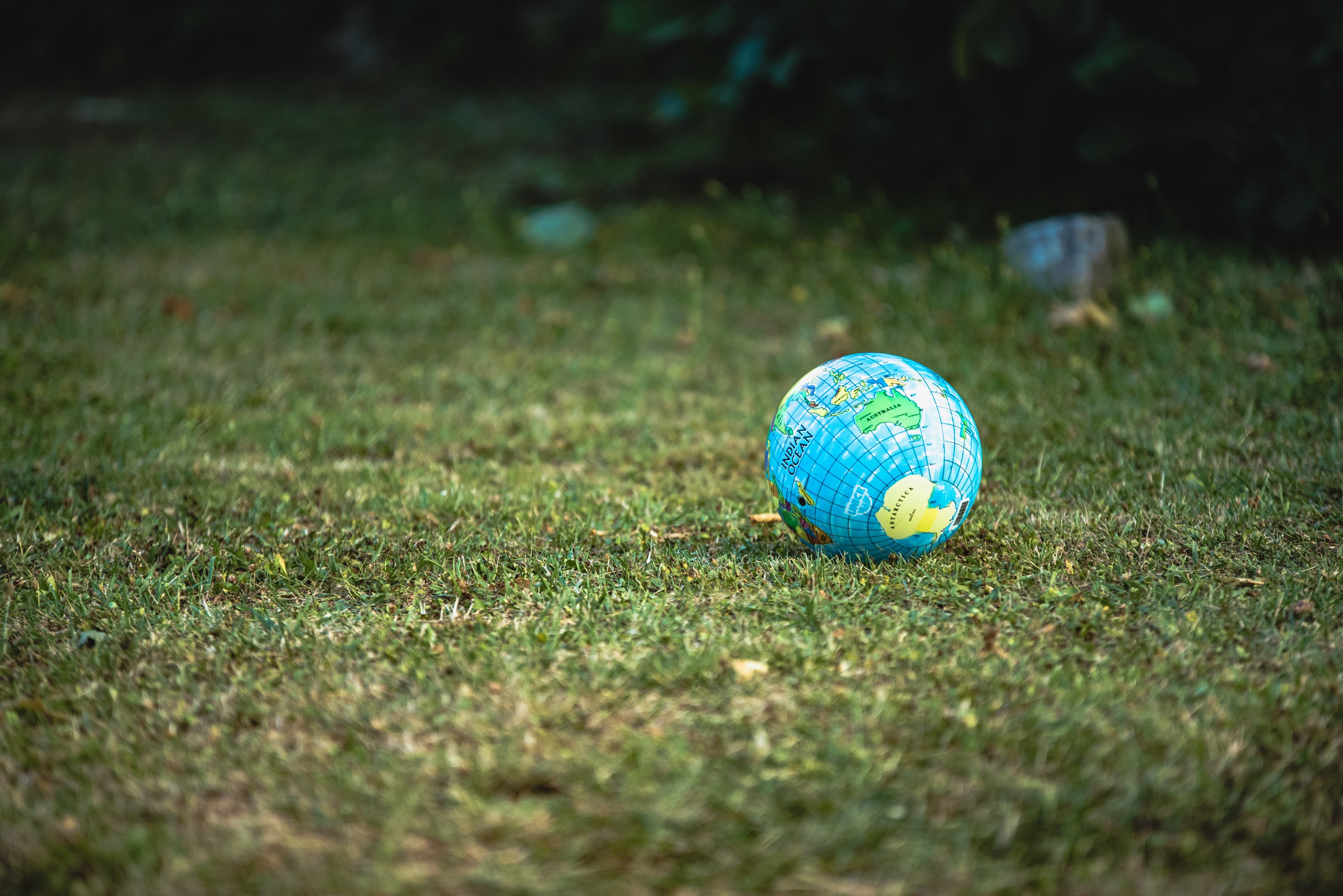 Globo terráqueo sobre césped verde, representando la conexión entre el planeta y los hábitos sostenibles.