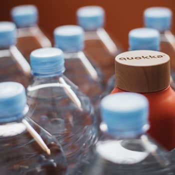 Botellas colocadas en contenedores de reciclaje, mostrando el impacto visible de los cambios en hábitos.